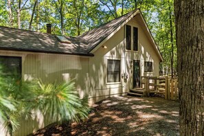A cabin with a sloped roof, a front porch, and a small deck. - Pet-Friendly w/Deck & Games in The Woods Resort (Hedgesville)