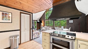 A modern kitchen with a large stove, wooden cabinets, and a view of the outdoors.