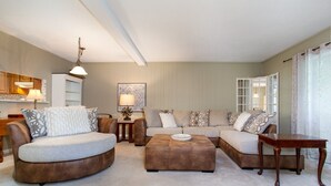 A living room with a sectional sofa, a coffee table, and a dining table. - Smoky Laurel Cottage - Mountain Views & Fireplace! (Gatlinburg)