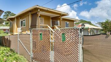 A two-story house with a fenced yard, a covered porch, and a satellite dish.