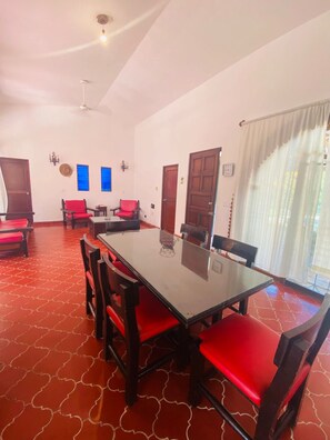 A dining area with a long table, red chairs, and a patterned floor. - Silvia's House (Manzanillo)