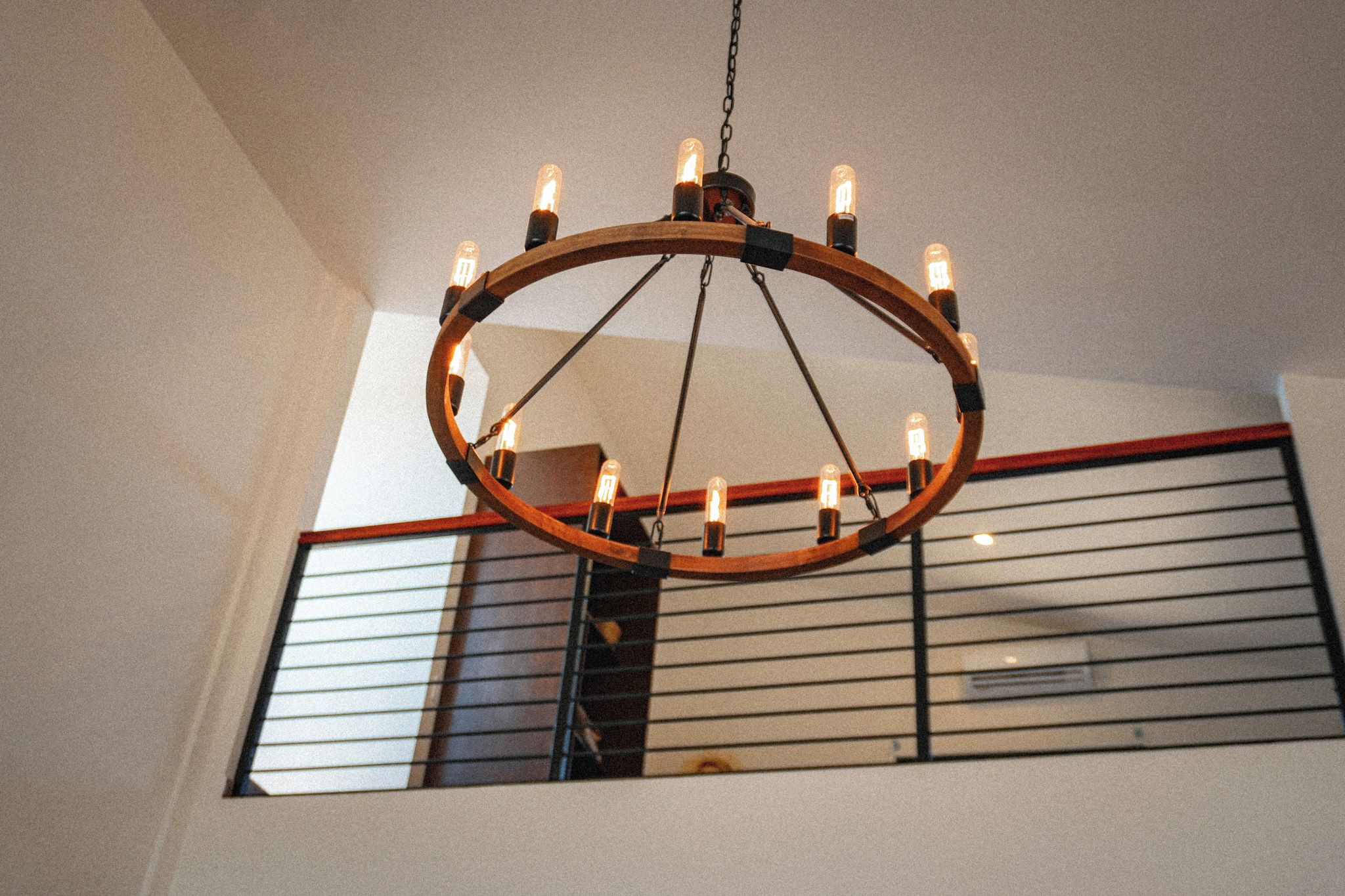 A circular chandelier with multiple bulbs hanging from a chain.
