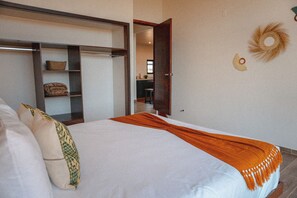Un dormitorio con cama, armario y vistas a una zona de cocina.