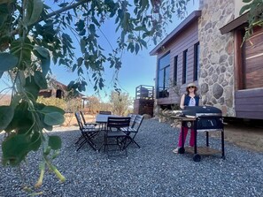 An outdoor seating area with a grill, a stone building, and a clear sky. - Casa completa 8 personas by 7 Valles (Valle de Guadalupe)