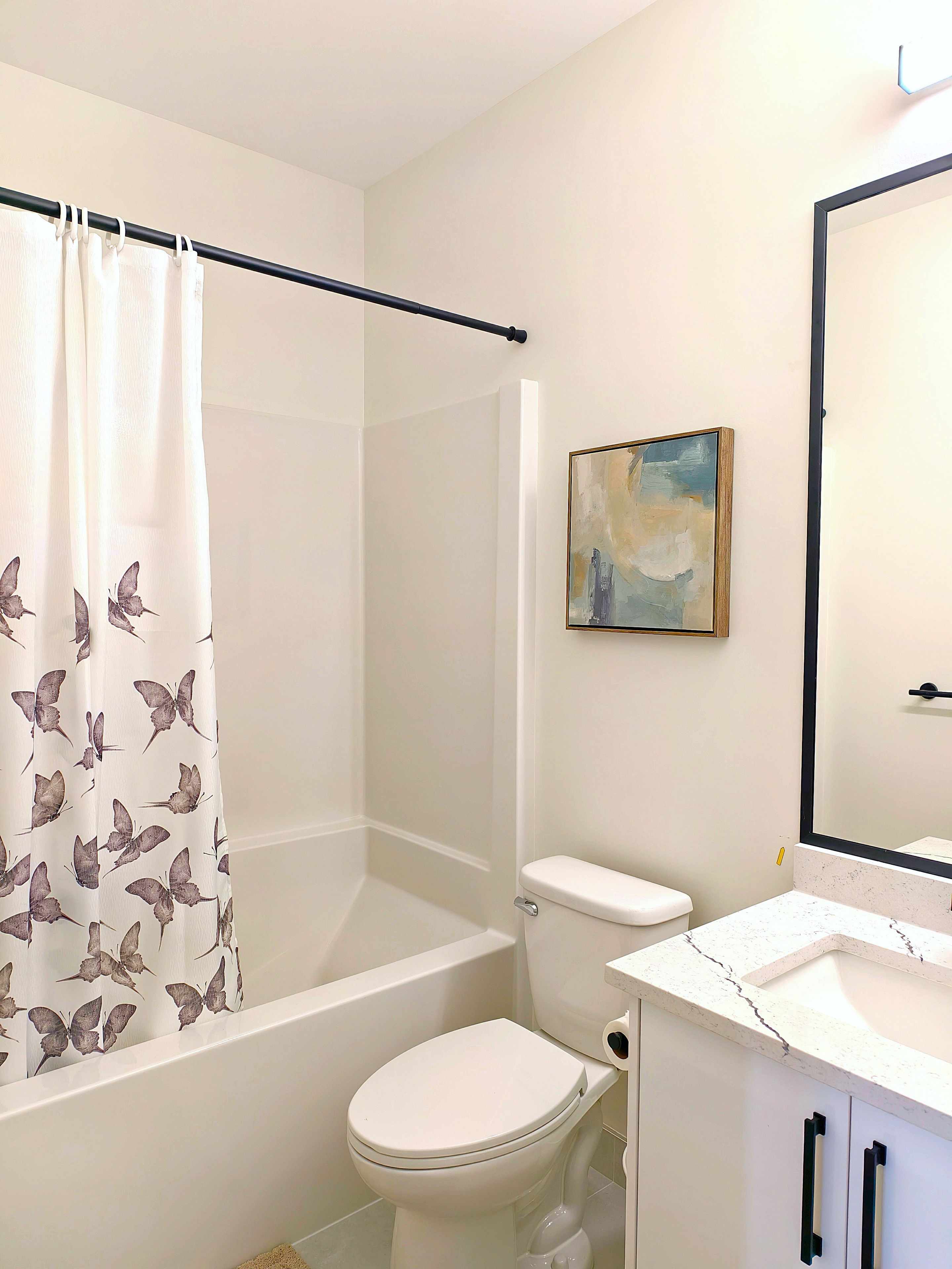A bathroom with a shower, toilet, and sink.