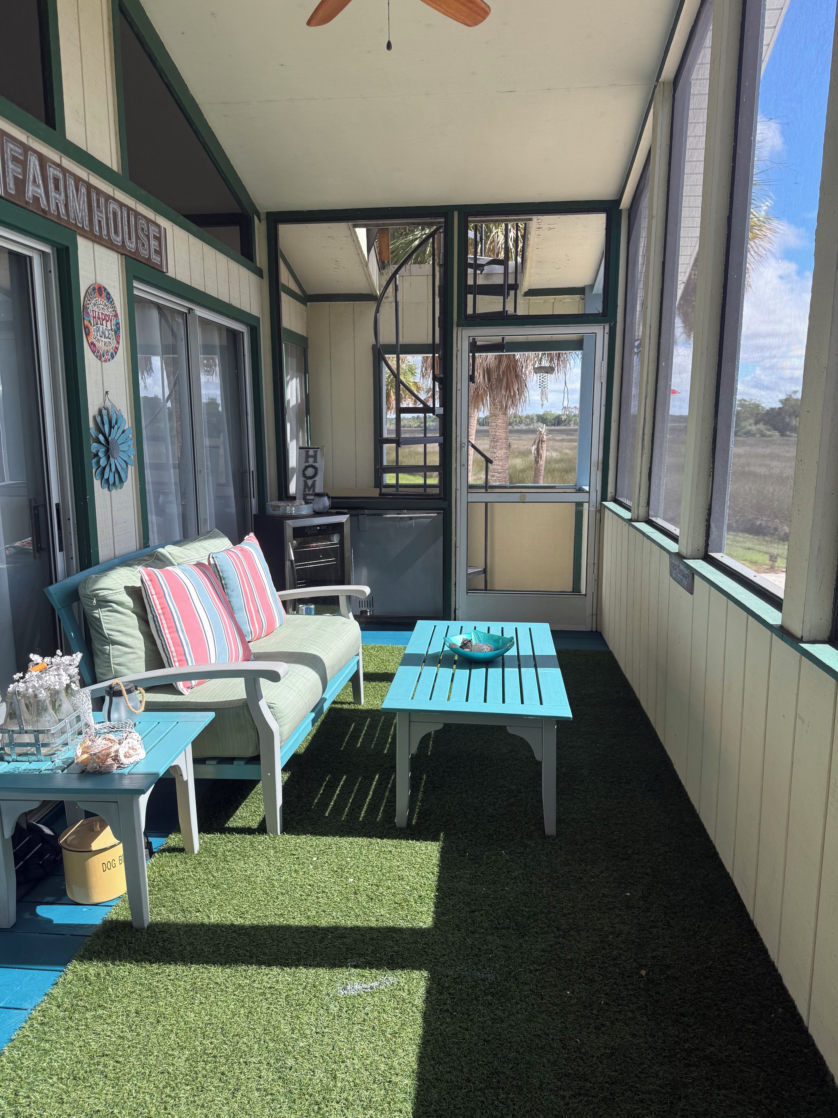 Un espacio exterior techado con un sofá, una mesa y vistas al exterior.