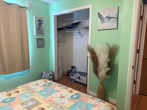 A bedroom with a bed, a closet, a door, and a wall with a picture. - 3-bedroom stilt home designed for hunters, fisherman, scallopers & nature lovers (Crystal River)
