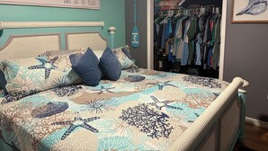 A bedroom with a bed, a closet, and a wall sign.