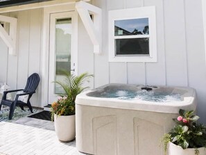 Ein Wellnessbereich mit Whirlpool, Topfpflanzen und einem Sessel.