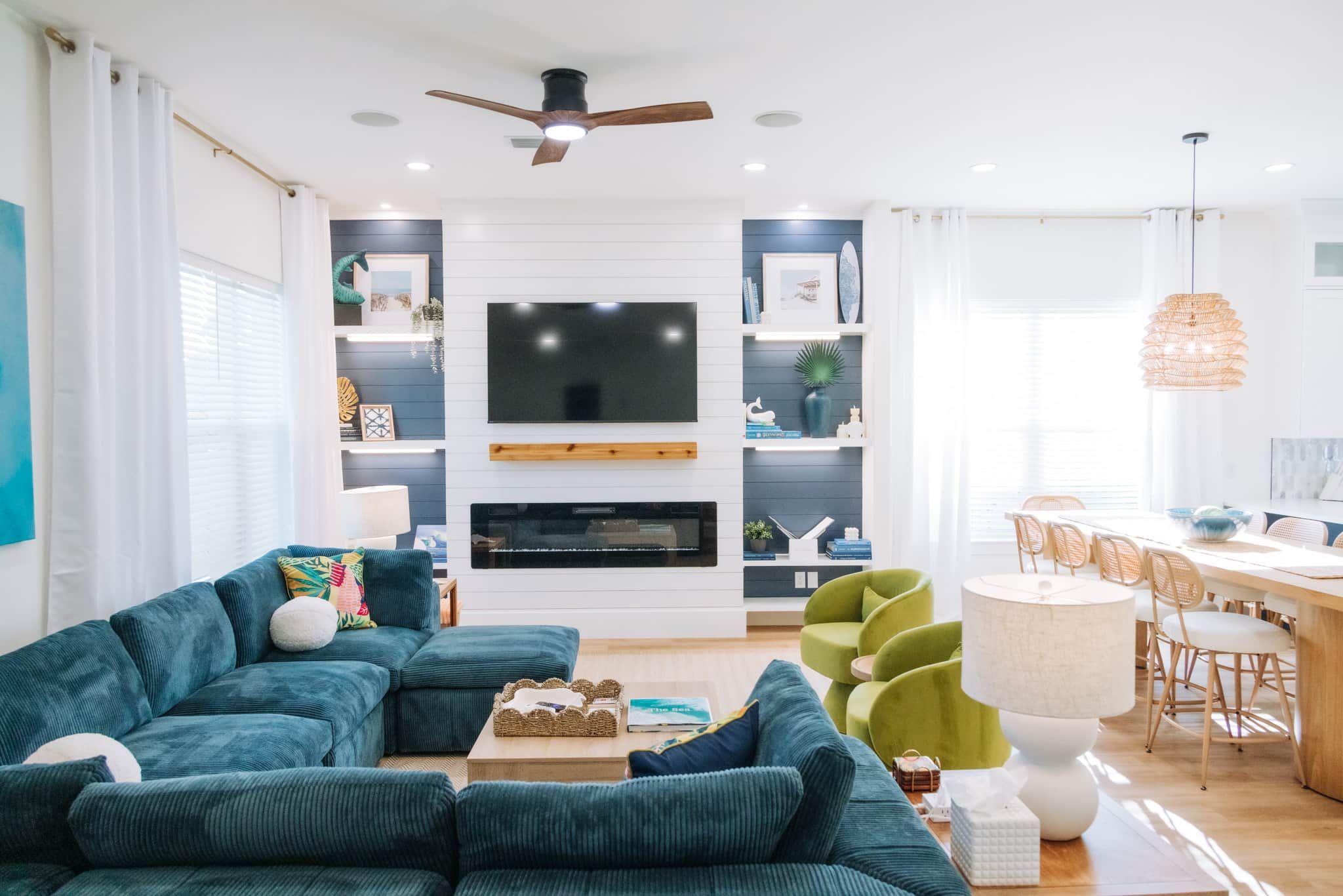 A modern living room with a sectional sofa, a fireplace, and a dining area with a table and chairs.