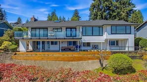 A modern two-story house with a balcony, a covered patio, and a well-maintained garden. - Cascade & Sammamish: 180° Mountain & Lake Views (Bellevue)