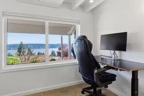 Ein Zimmer mit Schreibtisch, Stuhl und Fernseher.