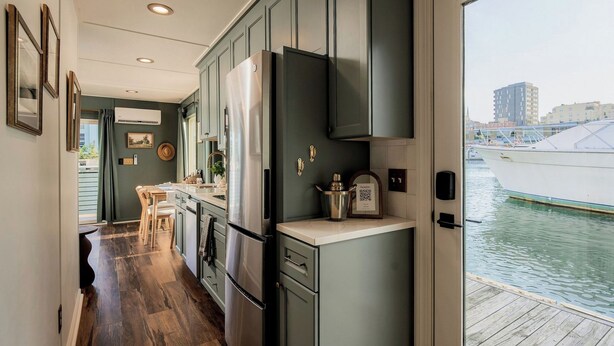 A compact kitchen with modern appliances, a dining area, and a view of the water.