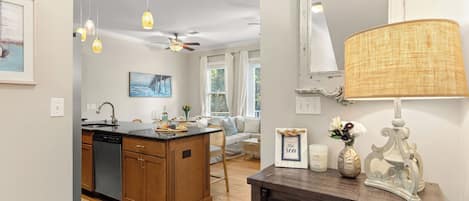 A kitchen with wooden cabinets, a dishwasher, and a dining area with a sofa and a table set for breakfast.