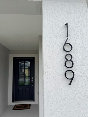 Husnummer 1689 på en hvid, struktureret væg.