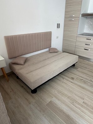 Un dormitorio minimalista con una cama, una mesita de noche y un armario de madera.