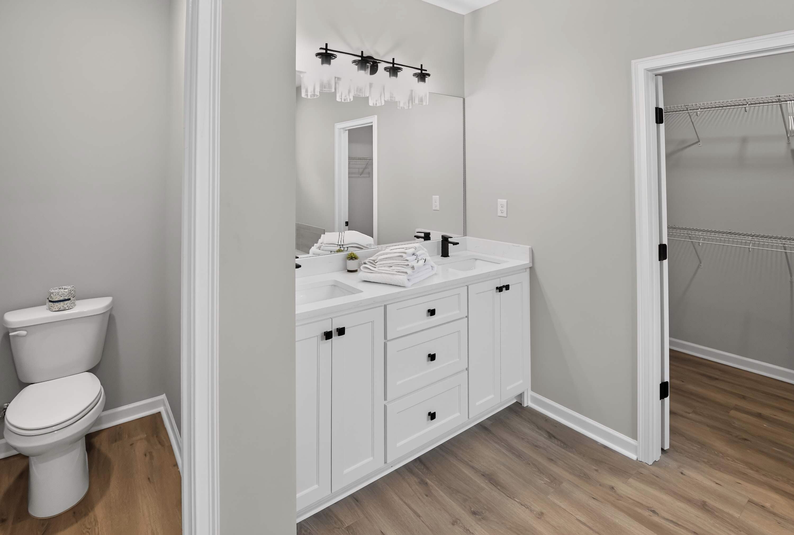 A modern bathroom with a toilet, a sink, and a mirror.