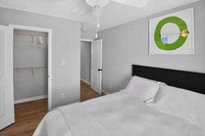A bedroom with a bed, a closet with hanging clothes, and a door leading to another room. - Spacious Oxford Retreats with Garage & Pool (Oxford)