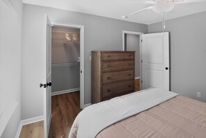Un dormitorio con cama, cómoda y armario con perchero.