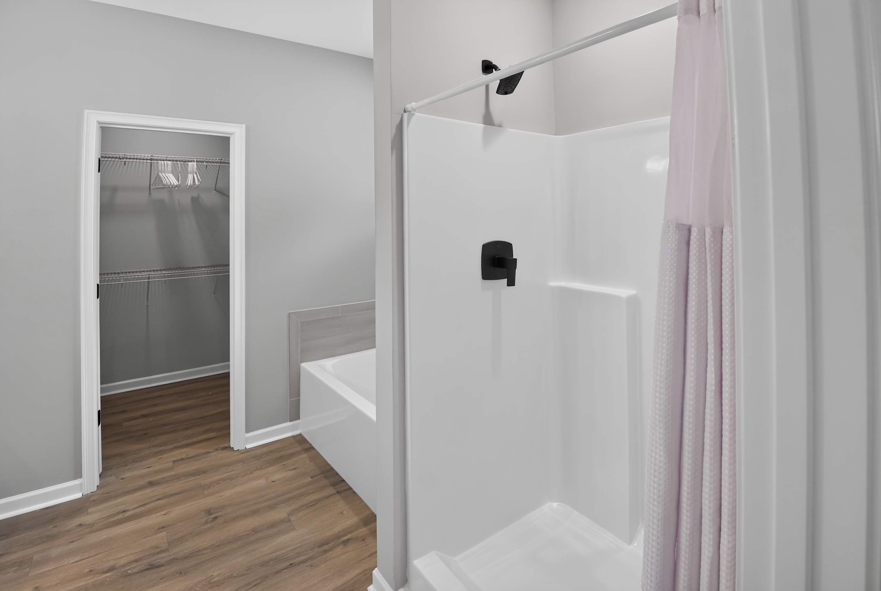 A modern bathroom with a walk-in shower, a toilet, and a shower curtain.
