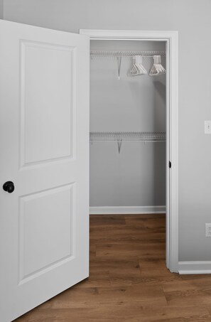 A white door leading to a closet with two shelves and hanging space. - Spacious Oxford Retreats with Garage & Pool (Oxford)