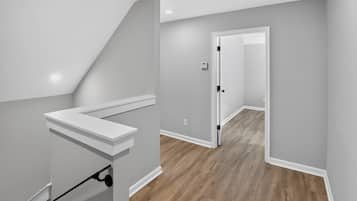 A modern interior with a staircase, a door leading to another room, and a light switch on the wall.