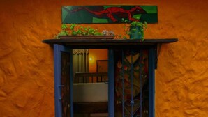 A small window with a blue frame, a door, and a decorative metal grill. - Violet - with terrace, hammock (Guatapé)