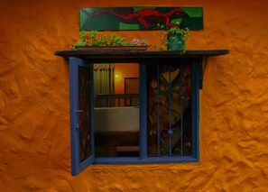 A small window with a blue frame, a door, and a decorative metal grill. - Violet - with terrace, hammock (Guatapé)