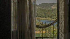 A room with a view of a landscape through a large window, a hammock, and a curtain. - Violet - with terrace, hammock (Guatapé)