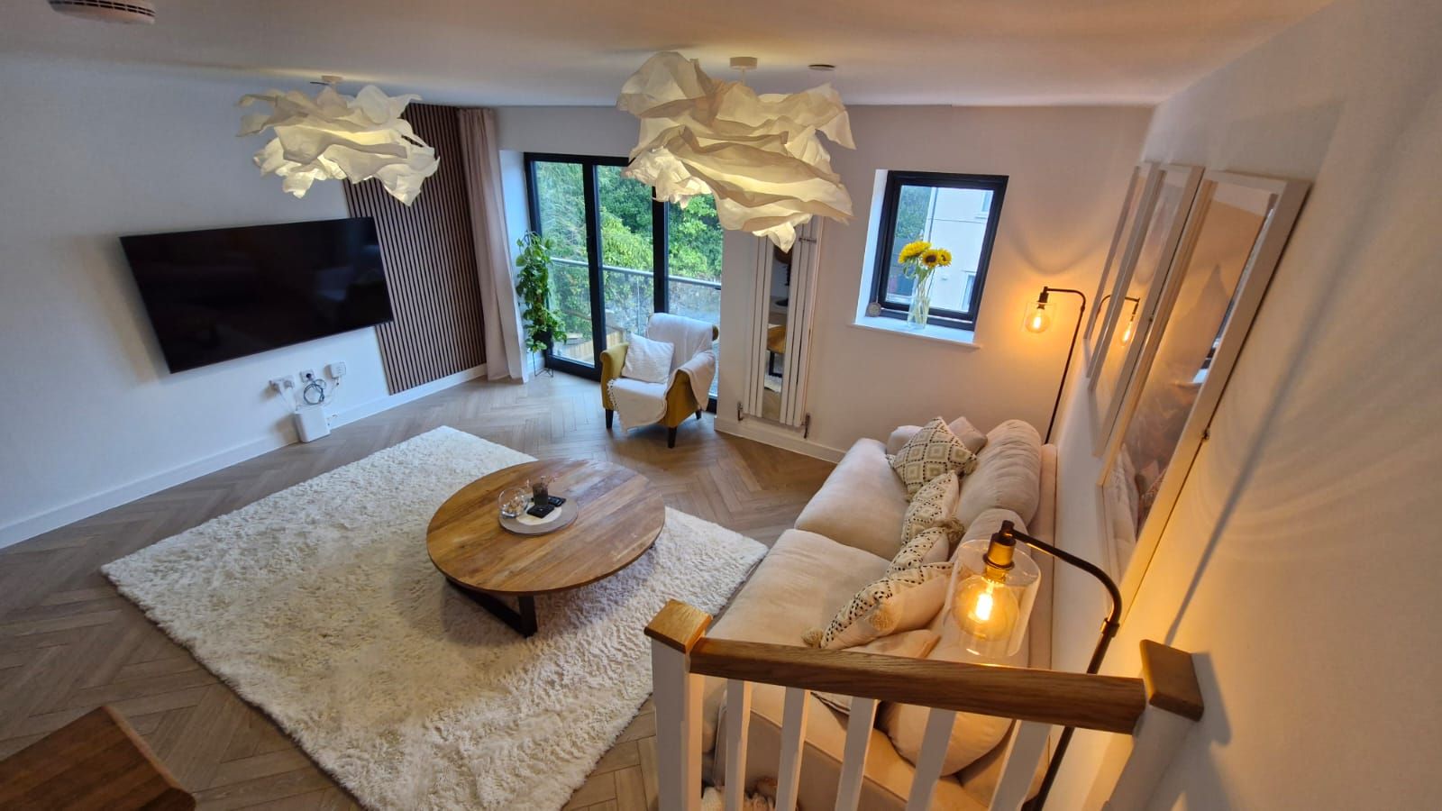 Un salon moderne avec un canapé, une table basse et un téléviseur fixé au mur.