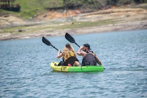 Two people kayaking on a calm body of water.