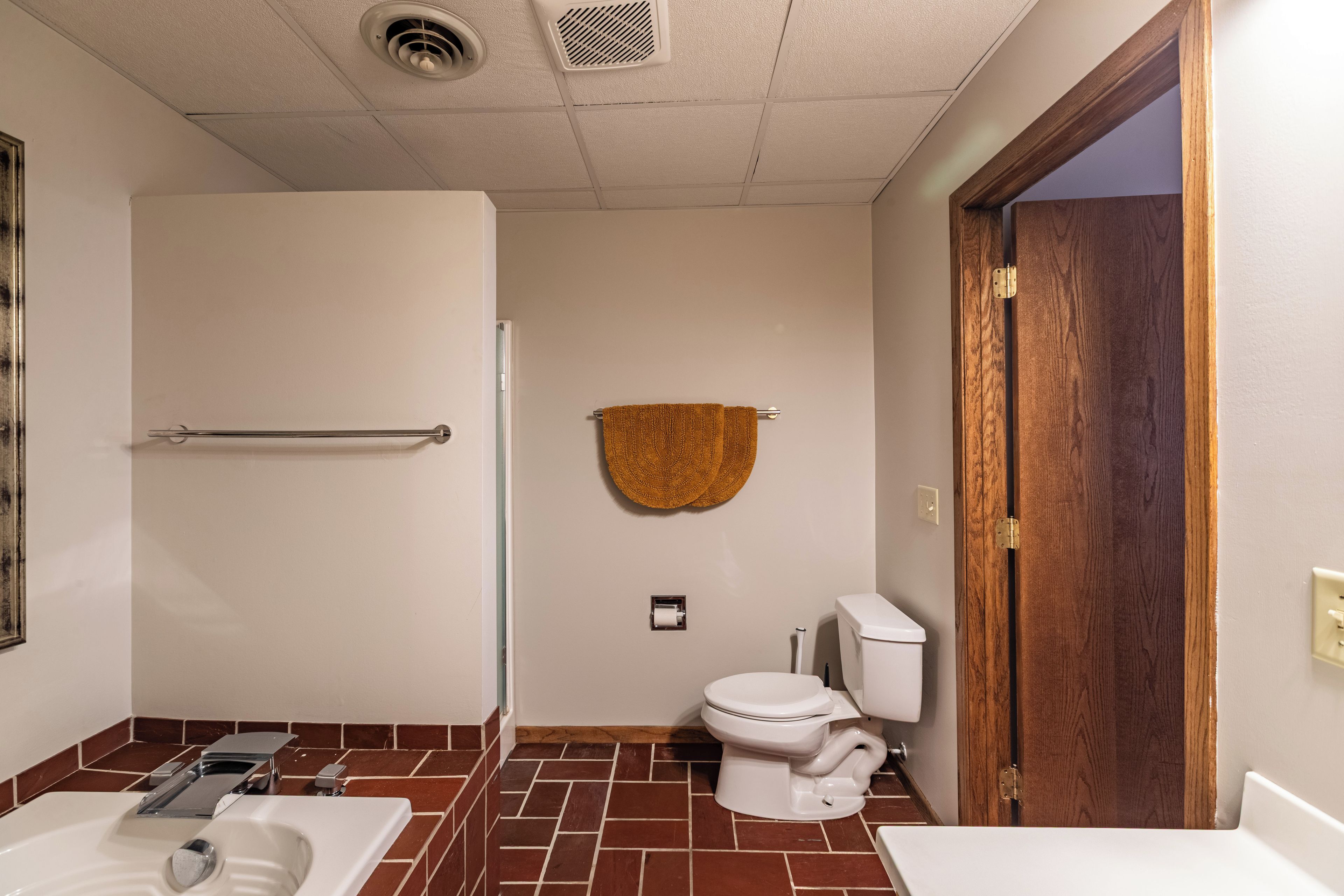 Une salle de bain comprenant des toilettes, un lavabo et un espace douche.
