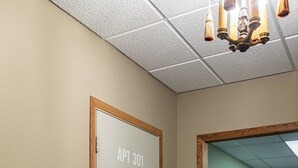 Ein Flur mit einer Tür, auf der 'APT 301' steht, und einem Holzregal.