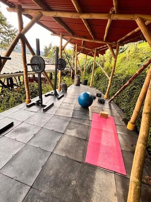 An outdoor gym area with exercise equipment, a blue exercise ball, and a red mat. - Tulipan - Single suite with lake view (Guatapé)