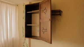 A room with a wooden cabinet with a hinged door, a small shelf, and a hook for hanging items. - Ivy - with lake view (Guatapé)