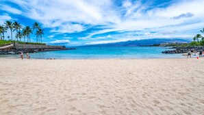 A beach with clear blue water, palm trees, and a rocky shoreline. - Mauna Lani Fairways Resort Townhouse w/ Beach Club (Waimea)