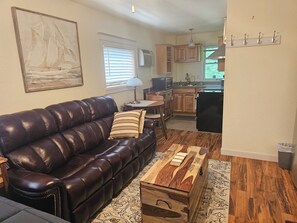 A living room with a leather sofa, a coffee table, and a painting on the wall. - Delightful NEW listing, freshly remodeled,Bayfield perfect for relax & adventure (Bayfield)