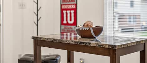 A marble table with a bowl of food and a red banner with white lettering in the background.