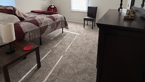 A bedroom with a bed, a desk, a chair, a dresser, and a window with blinds. - Hoosier House on S. Park Ave. Newly renovated, Close to IU Campus, (Bloomington)