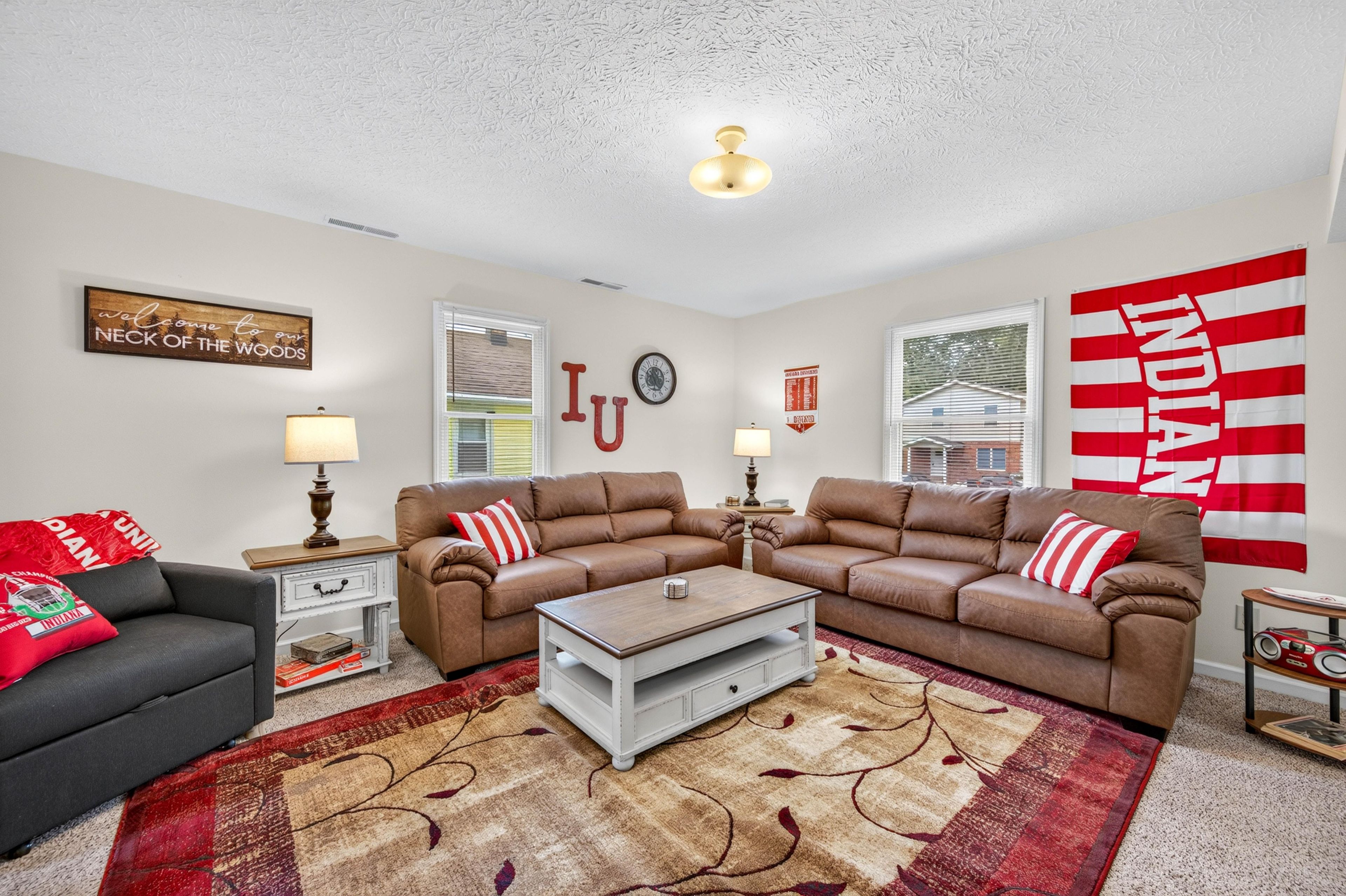 A living room with a sectional sofa, a coffee table, and a flag.