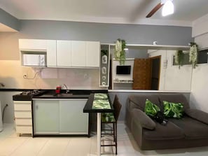 A modern kitchen with white cabinets, a black countertop, and a small island. - 204 - Cozy 2-bedroom apartment. (Belém)