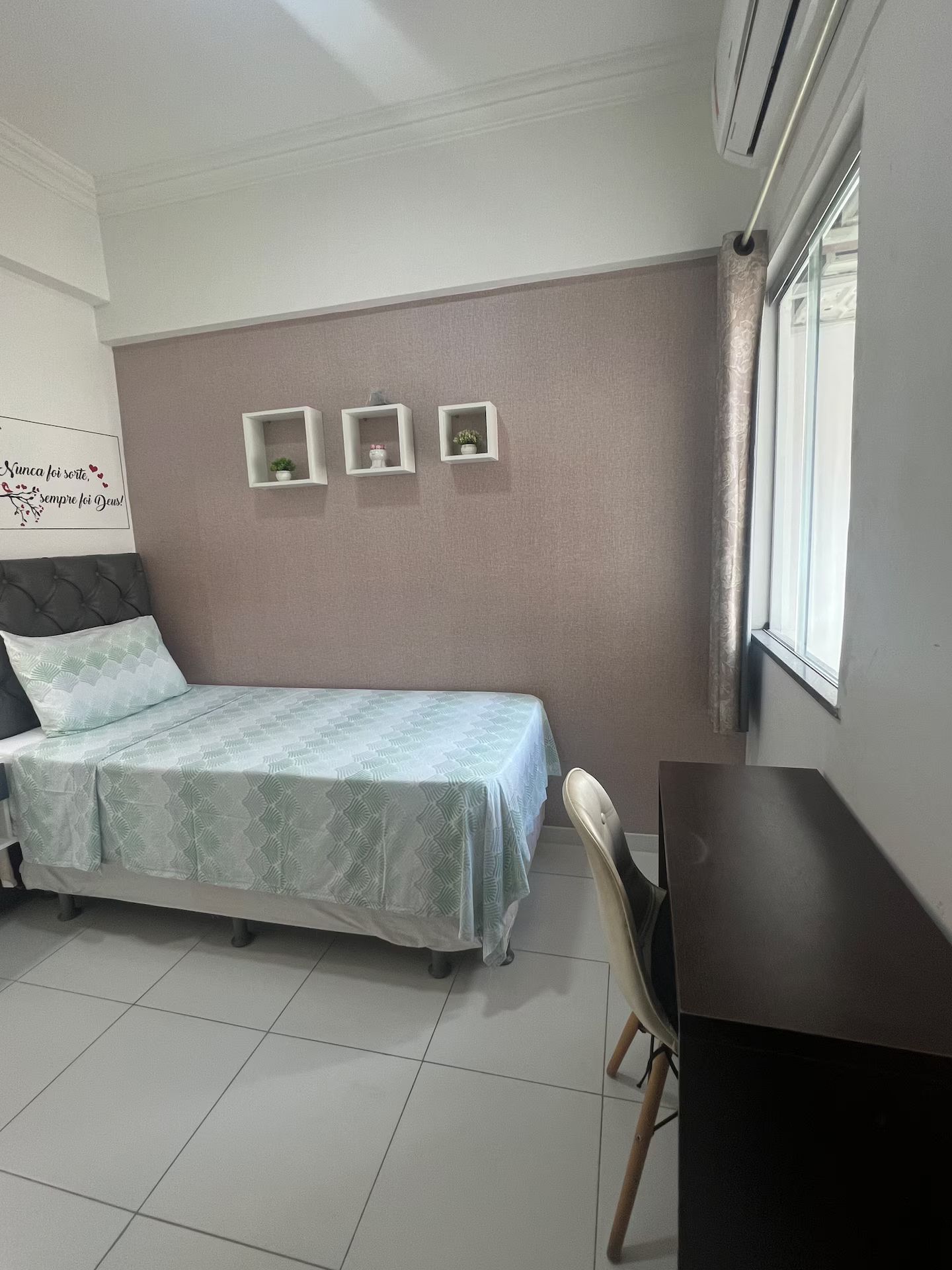 Ein Schlafzimmer mit einem Bett, einem Schreibtisch und drei Regalen an der Wand.