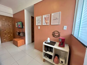 A modern living room with a television, a coffee station, and motivational wall art. - 204 - Cozy 2-bedroom apartment (Belém)