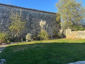 A stone building with a tiled roof, surrounded by a well-maintained lawn and various shrubs. - La Dolce Villa
Cosy stone Villa, Istria
Pet Friendly, 
Private pool (Kanfanar)