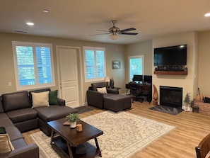 A living room with a sectional sofa, a coffee table, a fireplace, and a television. - Silver Pines Modern Retreat-3BR New Build (Shaver Lake)