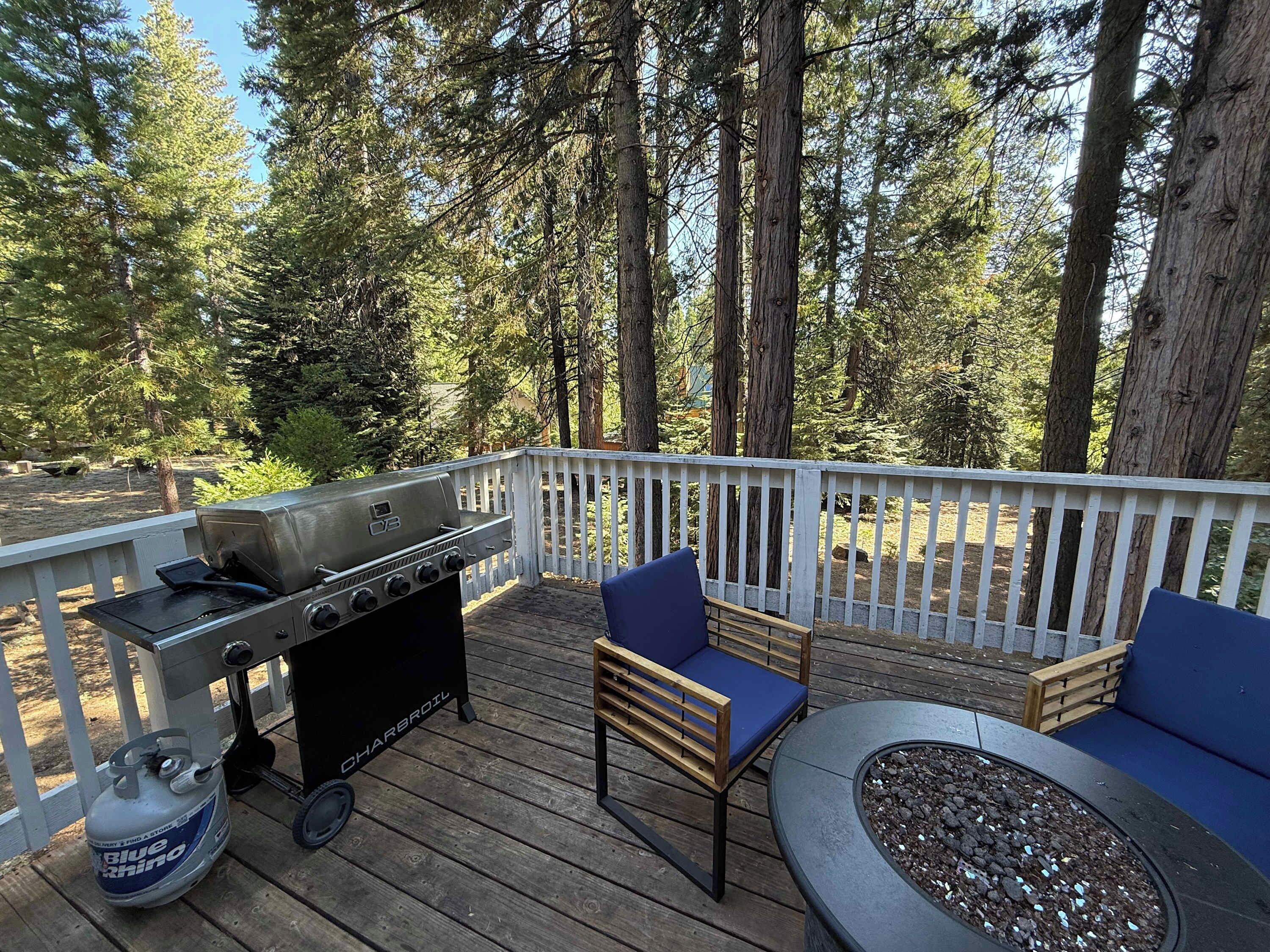 Eine Terrasse im Freien mit Grill, Sitzgelegenheit und Feuerstelle.