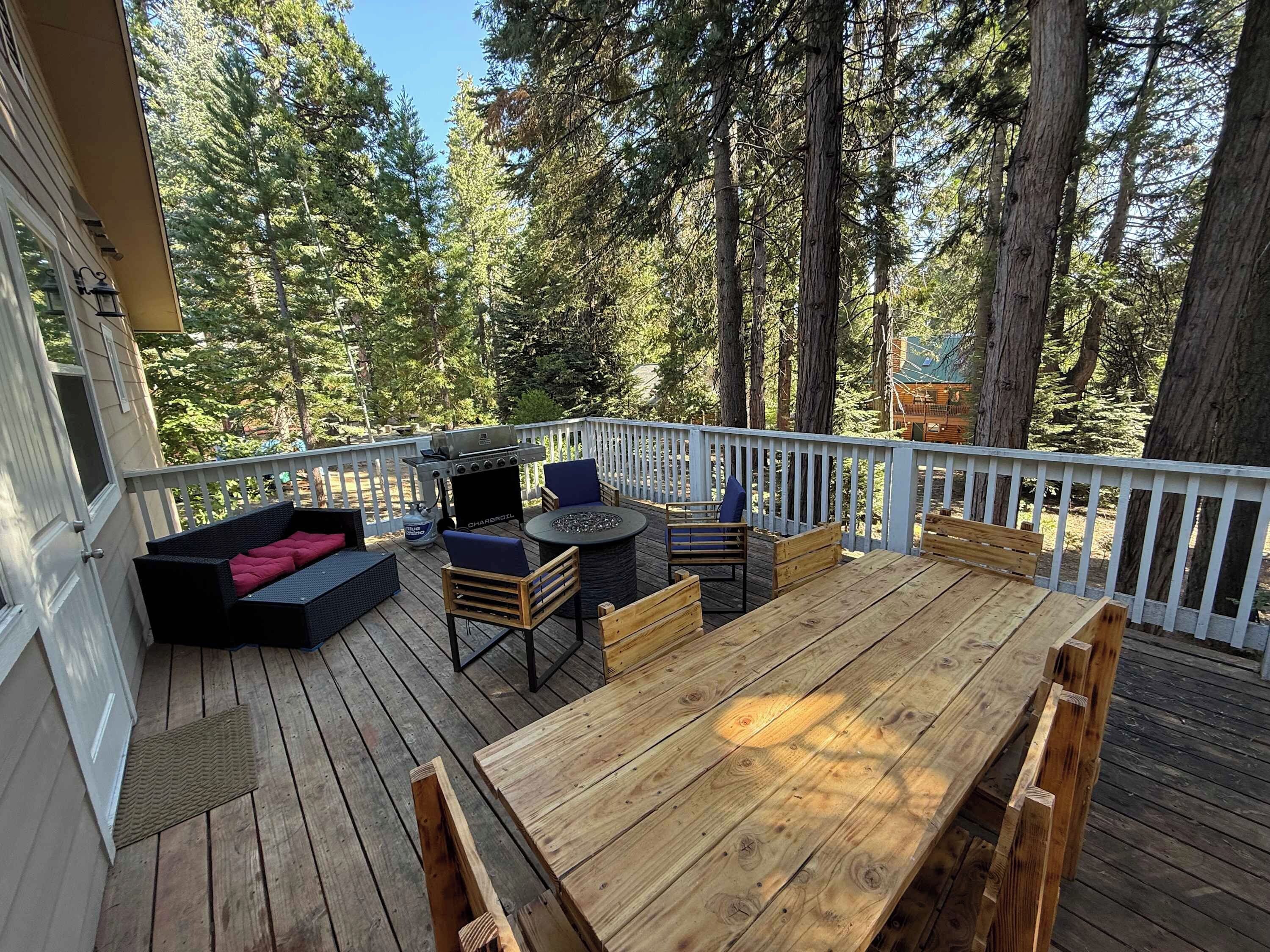 A wooden deck with outdoor furniture, including a sofa, chairs, and a table.