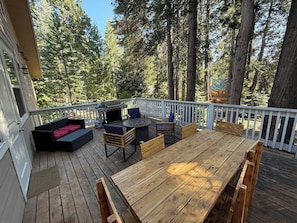 A wooden deck with outdoor furniture, including a sofa, chairs, and a table. - Silver Pines Modern Retreat-3BR New Build (Shaver Lake)
