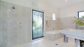 A bathroom with a shower, bathtub, and sink.