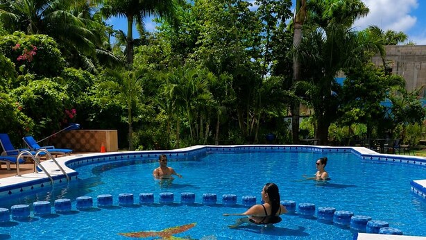 Una piscina con borde de azulejos y un diseño decorativo en el centro.